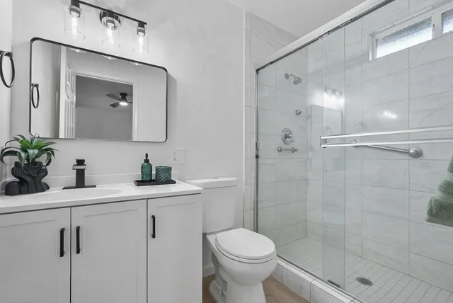 a bathroom with a sink a toilet and shower