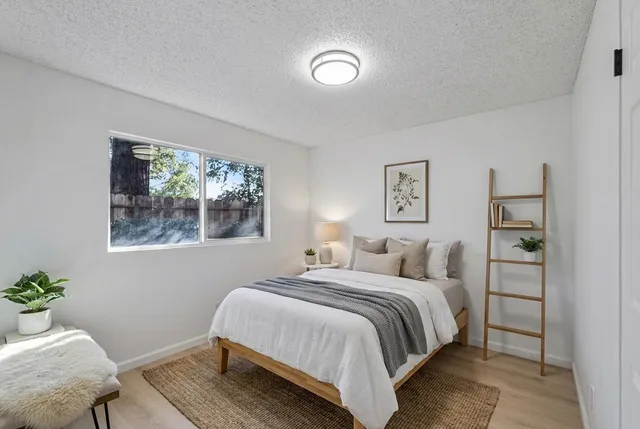 a bedroom with a bed and painting on the wall