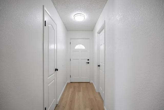 a view of a hallway with wooden floor