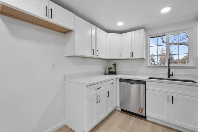 a kitchen with white cabinets and white appliances