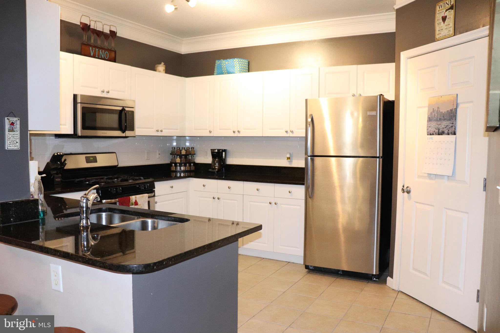 a kitchen with stainless steel appliances a refrigerator a sink a stove a microwave and a refrigerator
