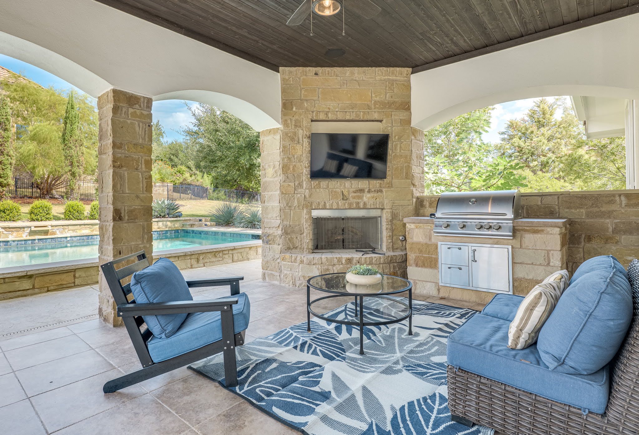 11612 Shoreview Overlook Austin, TX 78732 - Photo 37 of 40 An arched covered patio highlights a stone fireplace alongside a built-in outdoor kitchen.