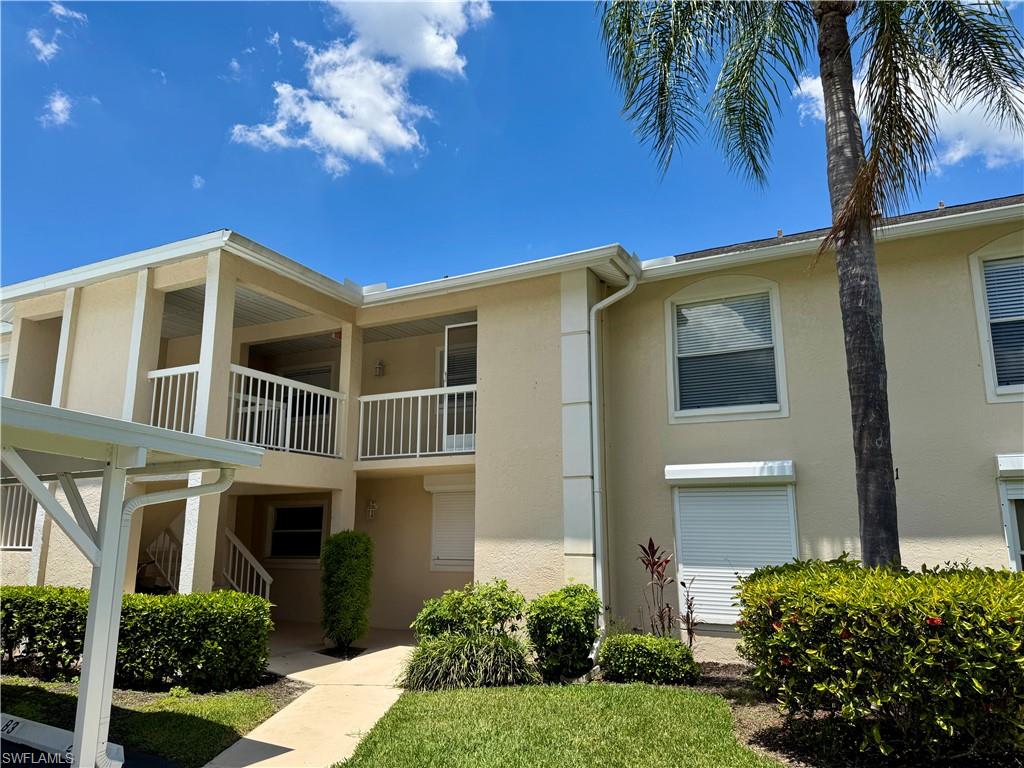 661 Squire Circle, Unit 101 Naples, FL 34104 - Photo 1 of 25 a front view of a house with a yard