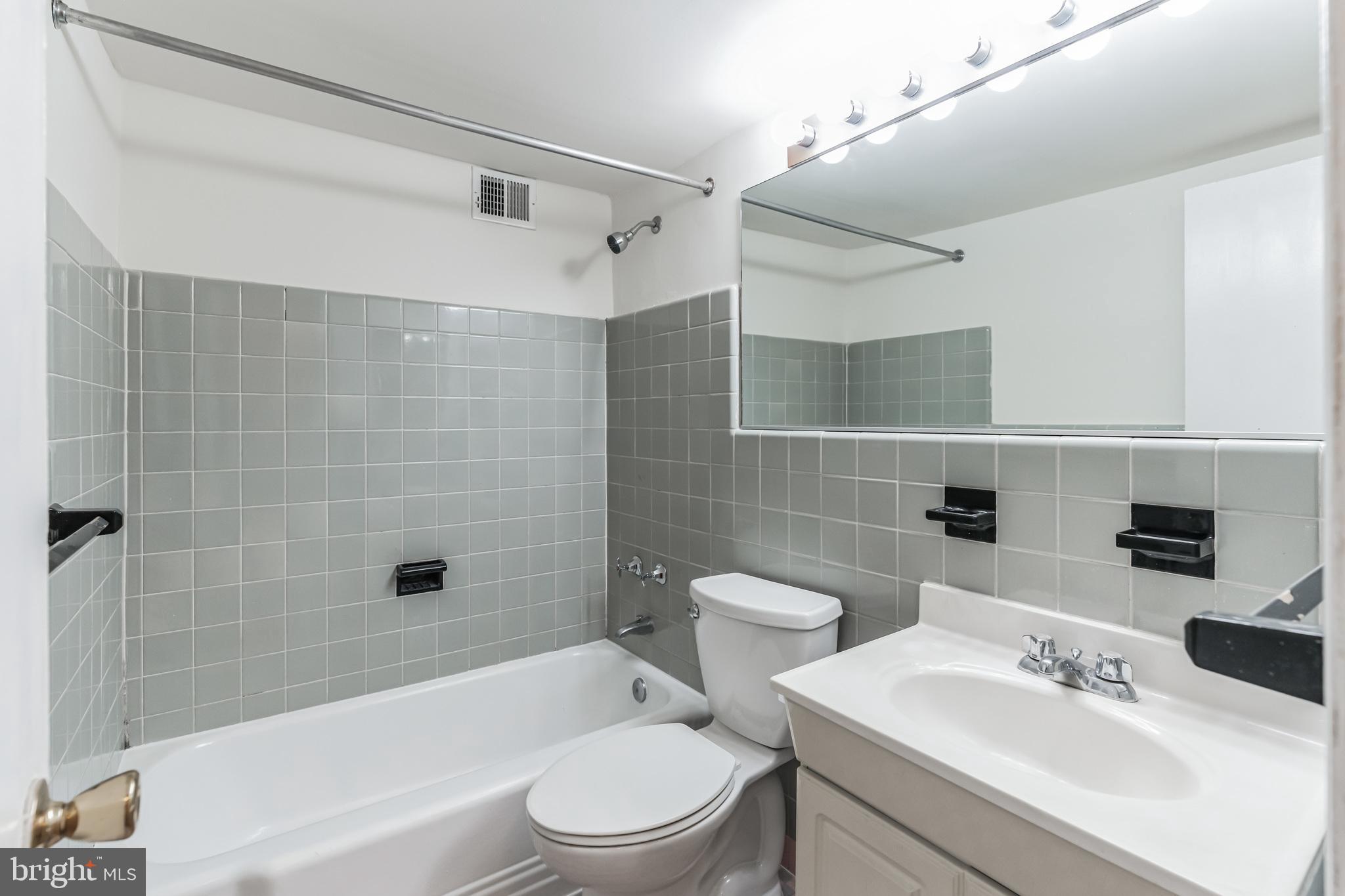2101 Chestnut Street, Unit 1102 Philadelphia, PA 19103 - Photo 7 of 17 a bathroom with a bathtub shower sink vanity and toilet