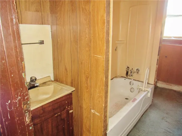 an empty room with windows ceiling fan and carpet