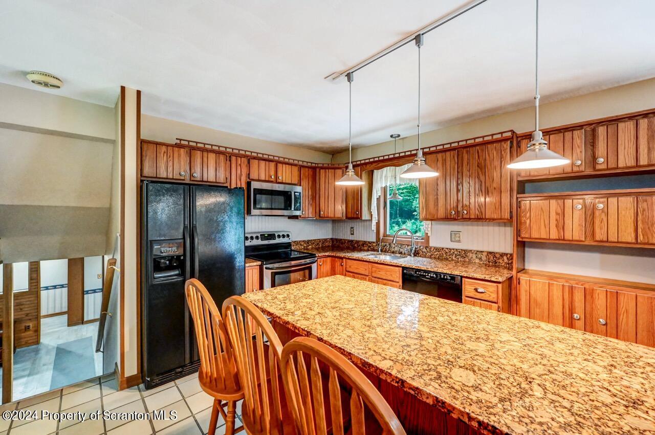 749 Elkview Drive Forest City, PA 18421 - Photo 17 of 73 a kitchen with stainless steel appliances kitchen island granite countertop a refrigerator a stove and a sink with wooden floor