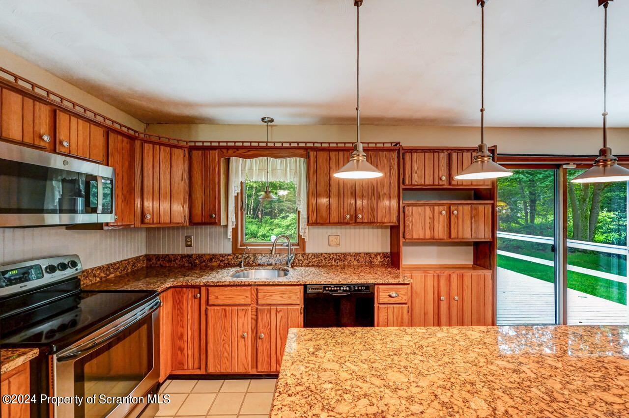 749 Elkview Drive Forest City, PA 18421 - Photo 19 of 73 a kitchen with stainless steel appliances kitchen island granite countertop a stove a sink and a microwave