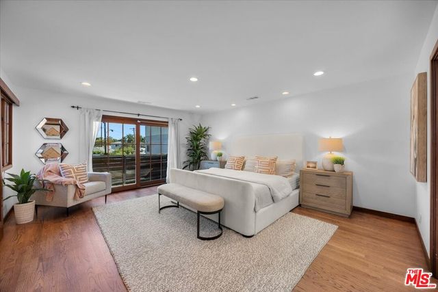 a spacious bedroom with a bed and wooden floor