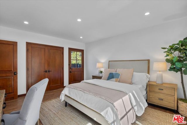 a bedroom with a bed and a potted plant on dresser