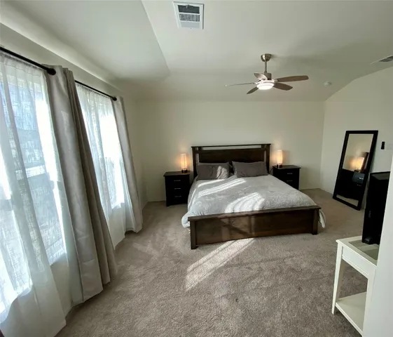 a bedroom with a bed and a large mirror