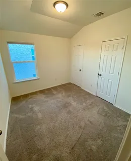 an empty room with a ceiling fan and a window