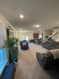 a living room with furniture kitchen area and a table