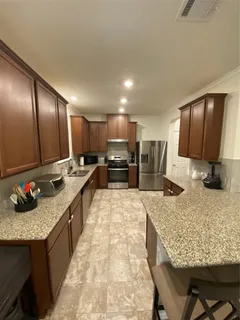 a large kitchen with kitchen island granite countertop a large counter top and refrigerator