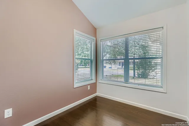 a view of a room with wooden floor and a window