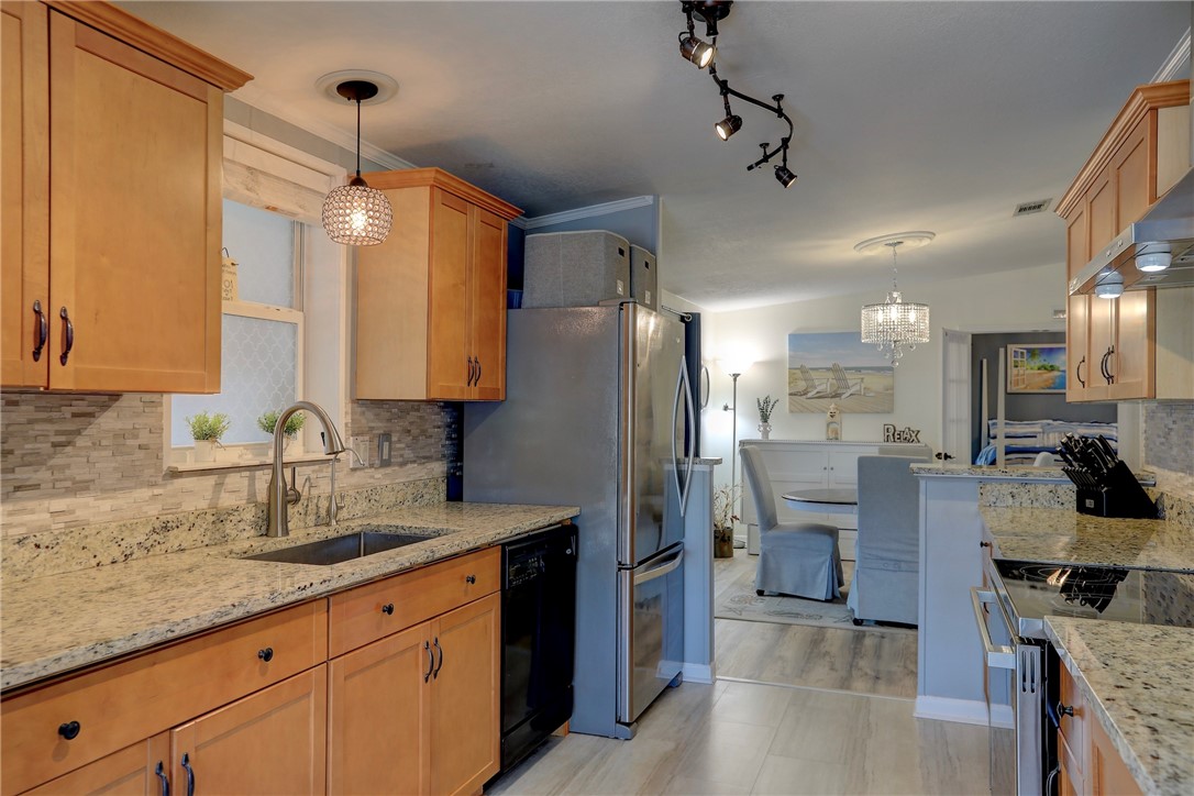 809 Lychee Drive Barefoot Bay, FL 32976 - Photo 12 of 36 a kitchen with stainless steel appliances granite countertop a sink refrigerator and cabinets
