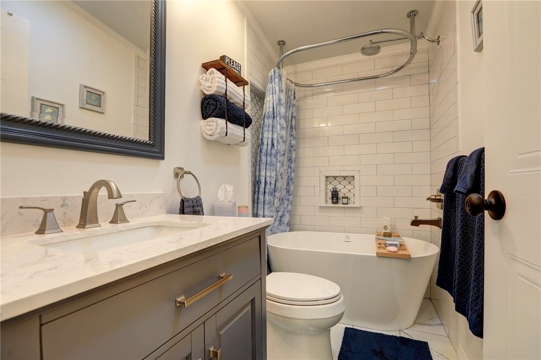 809 Lychee Drive Barefoot Bay, FL 32976 - Photo 21 of 36 a bathroom with a granite countertop sink toilet and shower