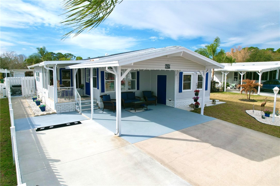 809 Lychee Drive Barefoot Bay, FL 32976 - Photo 3 of 36 a view of a house with a backyard and porch