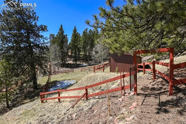 a view of a house with a yard and wooden fence