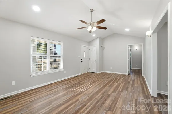 wooden floor fireplace and windows in an empty room