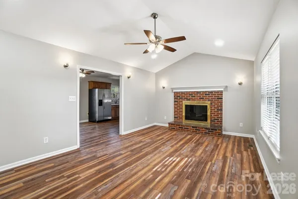 a view of an empty room with a fireplace and a window