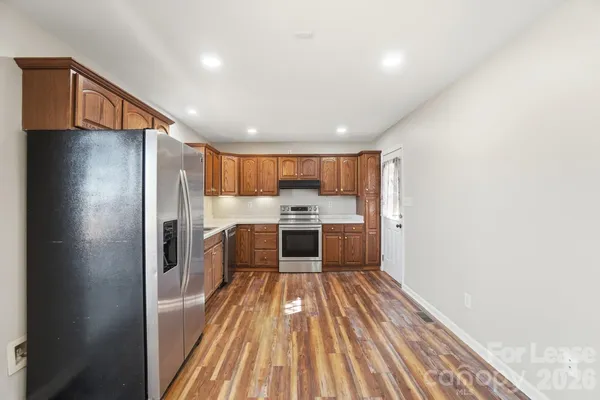 a kitchen with stainless steel appliances granite countertop a sink stove and cabinets