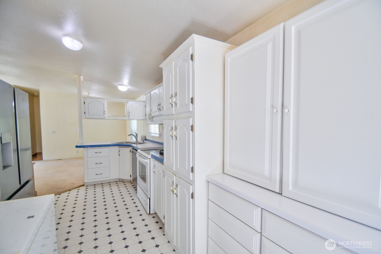 930 Tipsoo Loop North Rainier, WA 98576 - Photo 14 of 40 a kitchen with a refrigerator and white cabinets