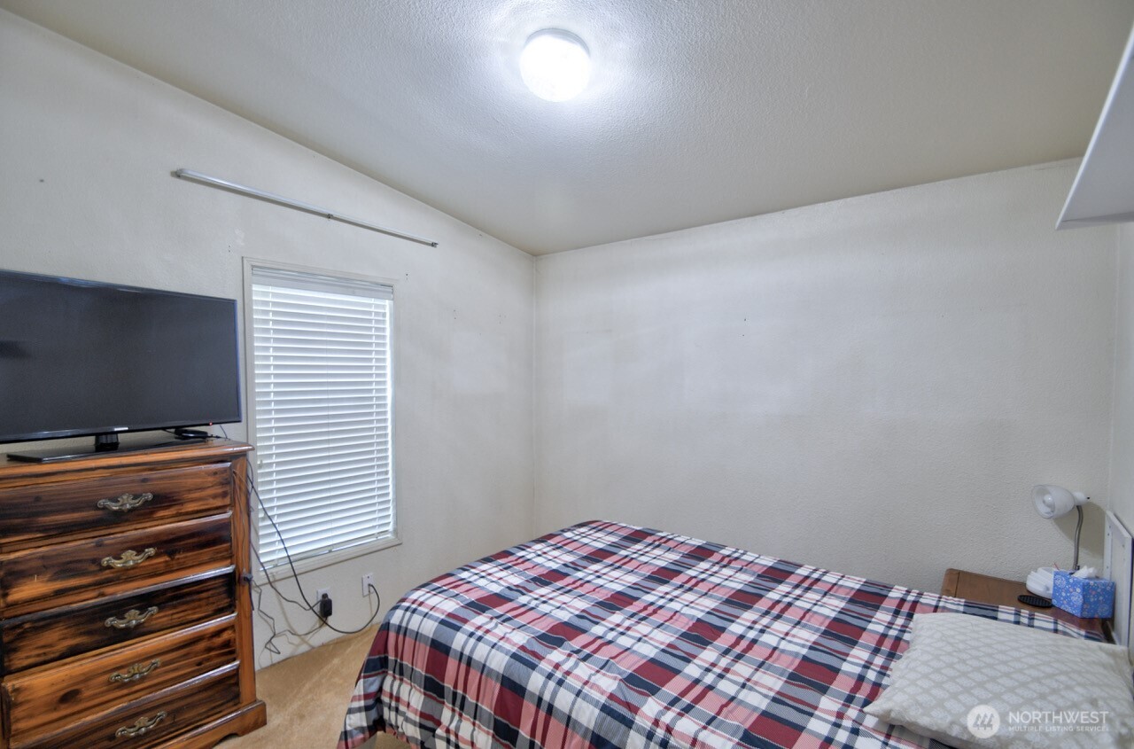 930 Tipsoo Loop North Rainier, WA 98576 - Photo 21 of 40 a bedroom with a bed and flat screen tv