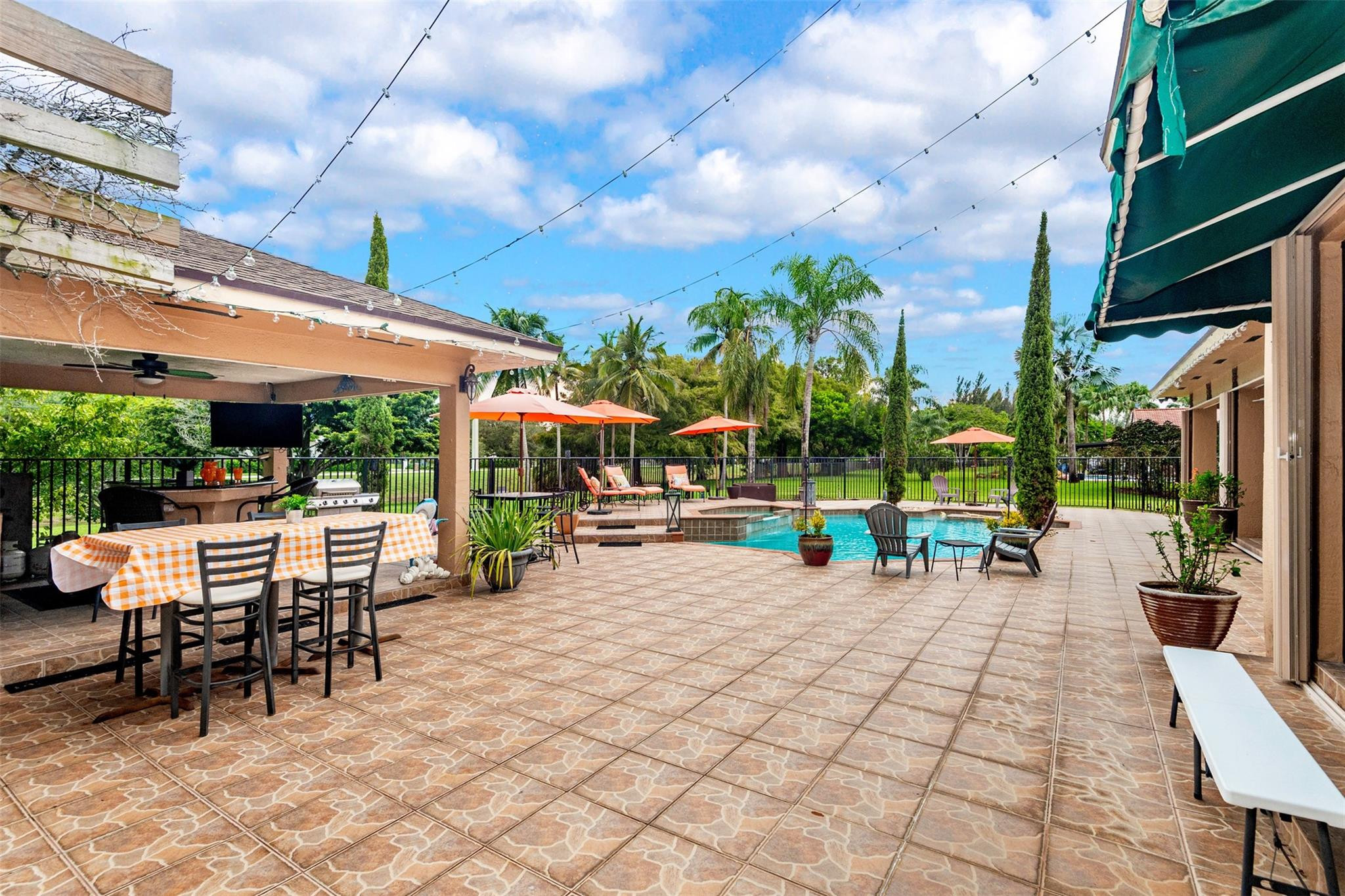 3151 Southwest 135th Terrace Davie, FL 33330 - Photo 53 of 74 a view of a patio with dining table and chairs with a small yard