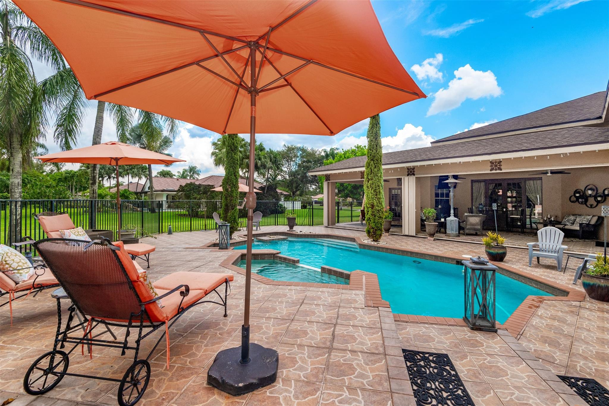 3151 Southwest 135th Terrace Davie, FL 33330 - Photo 57 of 74 a view of a swimming pool with a table and chairs under an umbrella