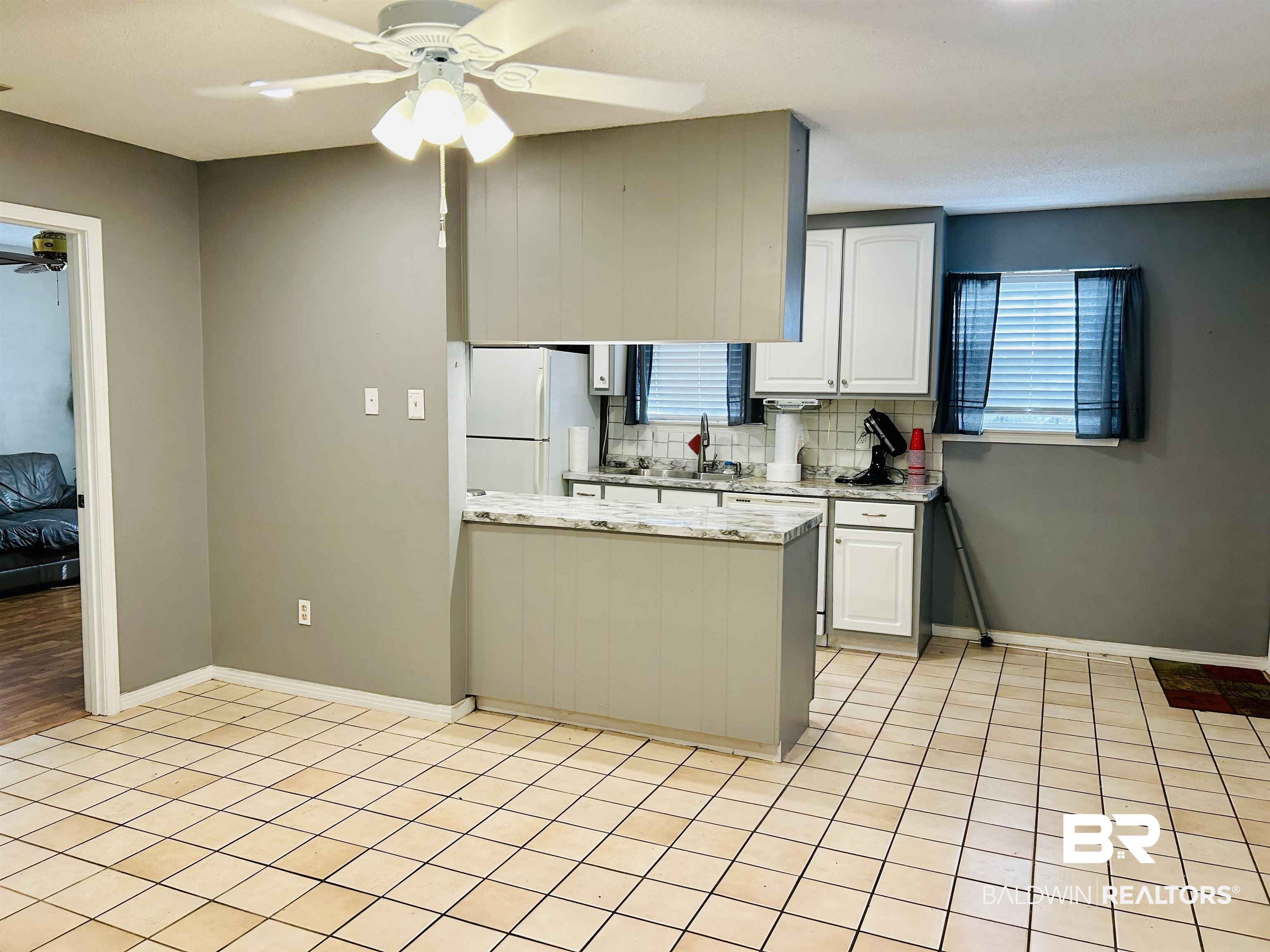 5925 Dixie Lane Mobile, AL 36693 - Photo 15 of 19 Kitchen with white refrigerator, white cabinetry, ceiling fan, and decorative backsplash