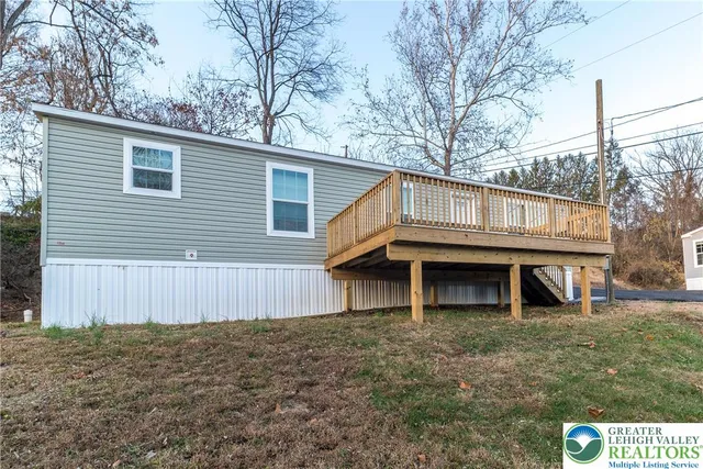 a view of a house with a large window and wooden fence