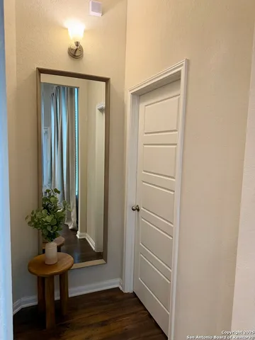 a view of a hallway with wooden floor and a cabinet