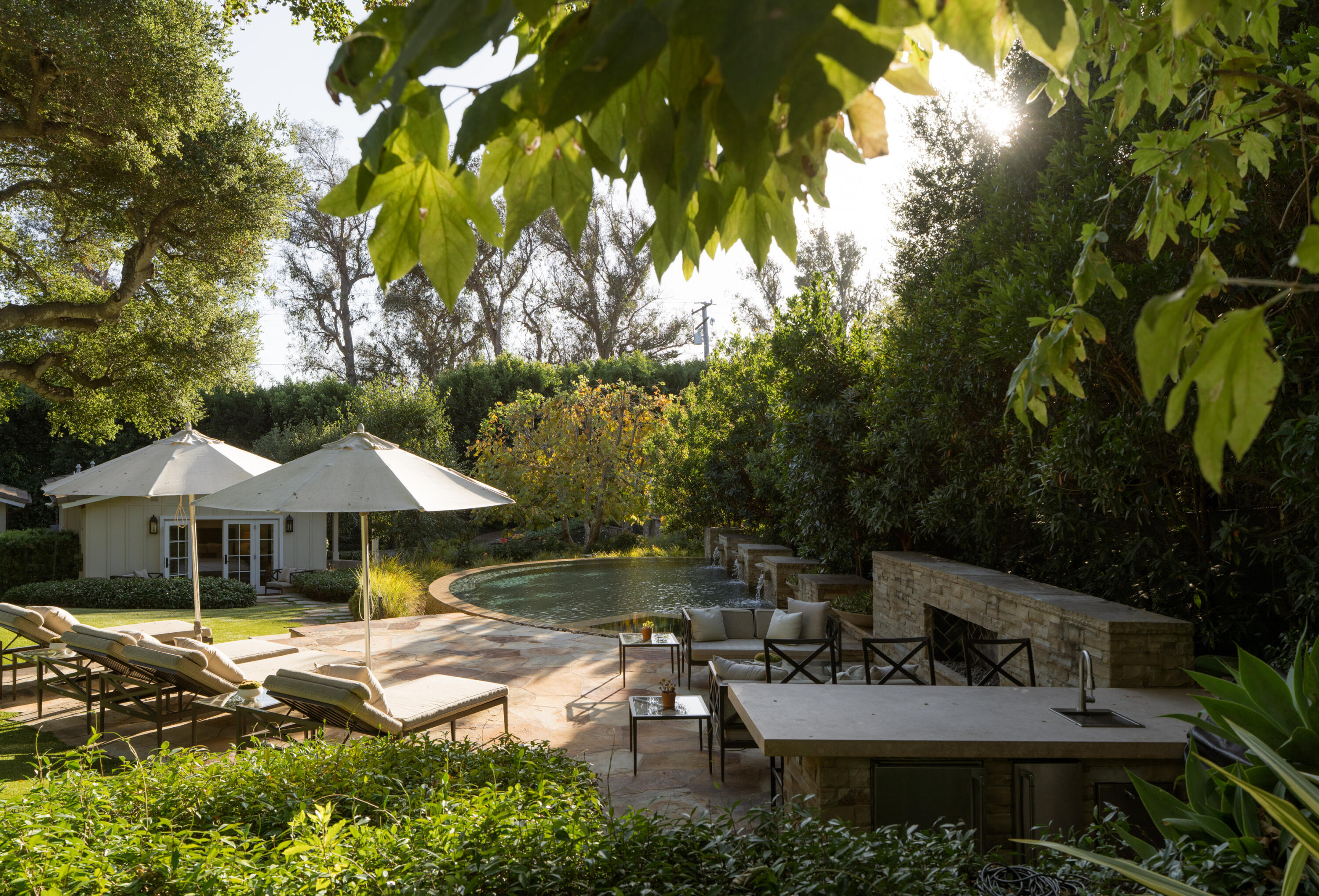 a backyard of a house with table and chairs under an umbrella