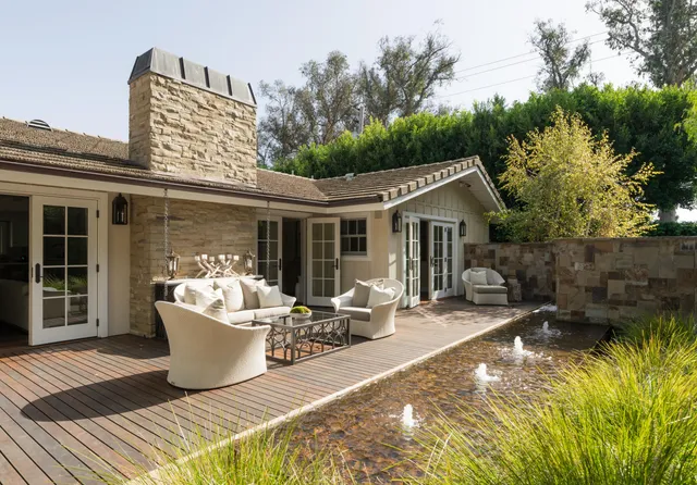 a view of a house with backyard sitting area and swimming pool