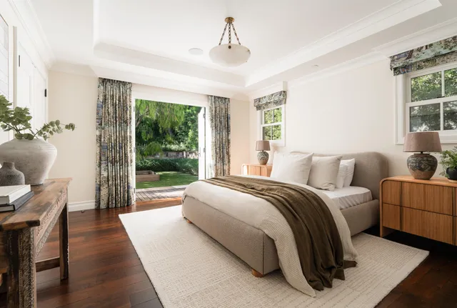 a spacious bedroom with a bed and glass window