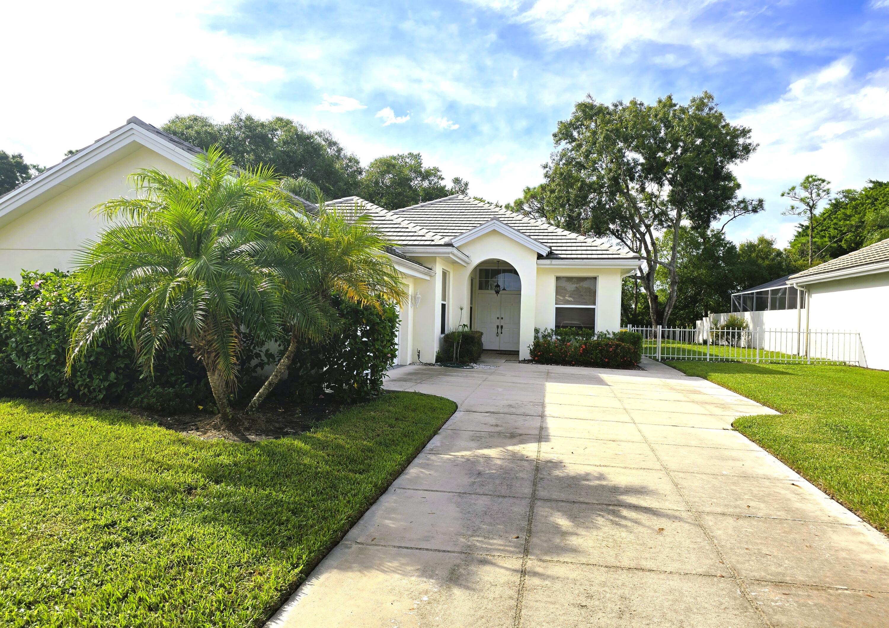 5131 Southeast Sweetbrier Terrace Hobe Sound, FL 33455 - Photo 1 of 18 a view of house with garden and tall tress