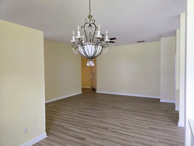 a view of a room with wooden floor and chandelier