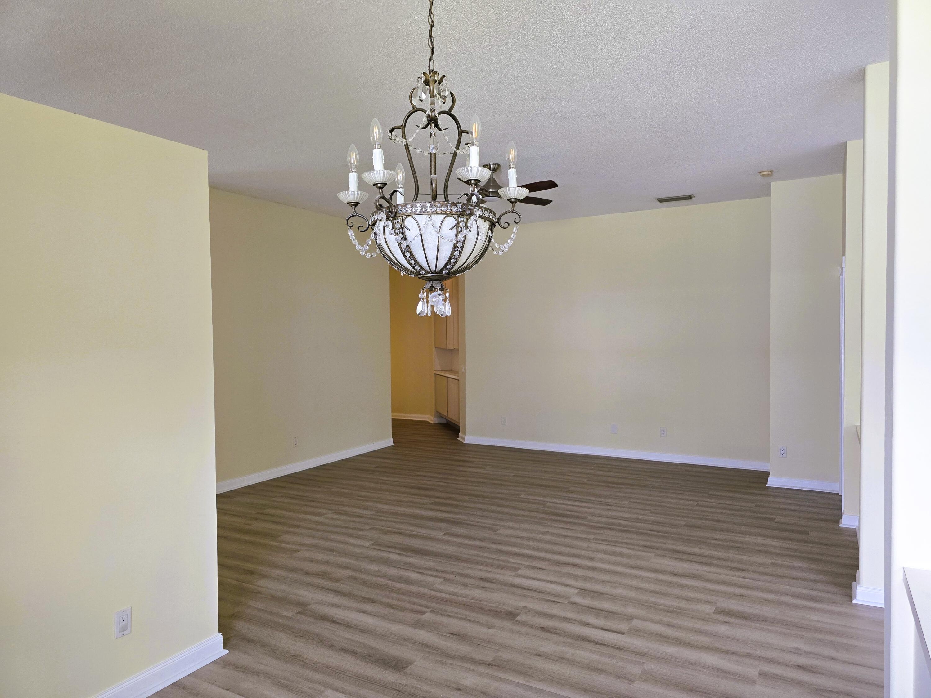 5131 Southeast Sweetbrier Terrace Hobe Sound, FL 33455 - Photo 4 of 18 a view of a room with wooden floor and chandelier