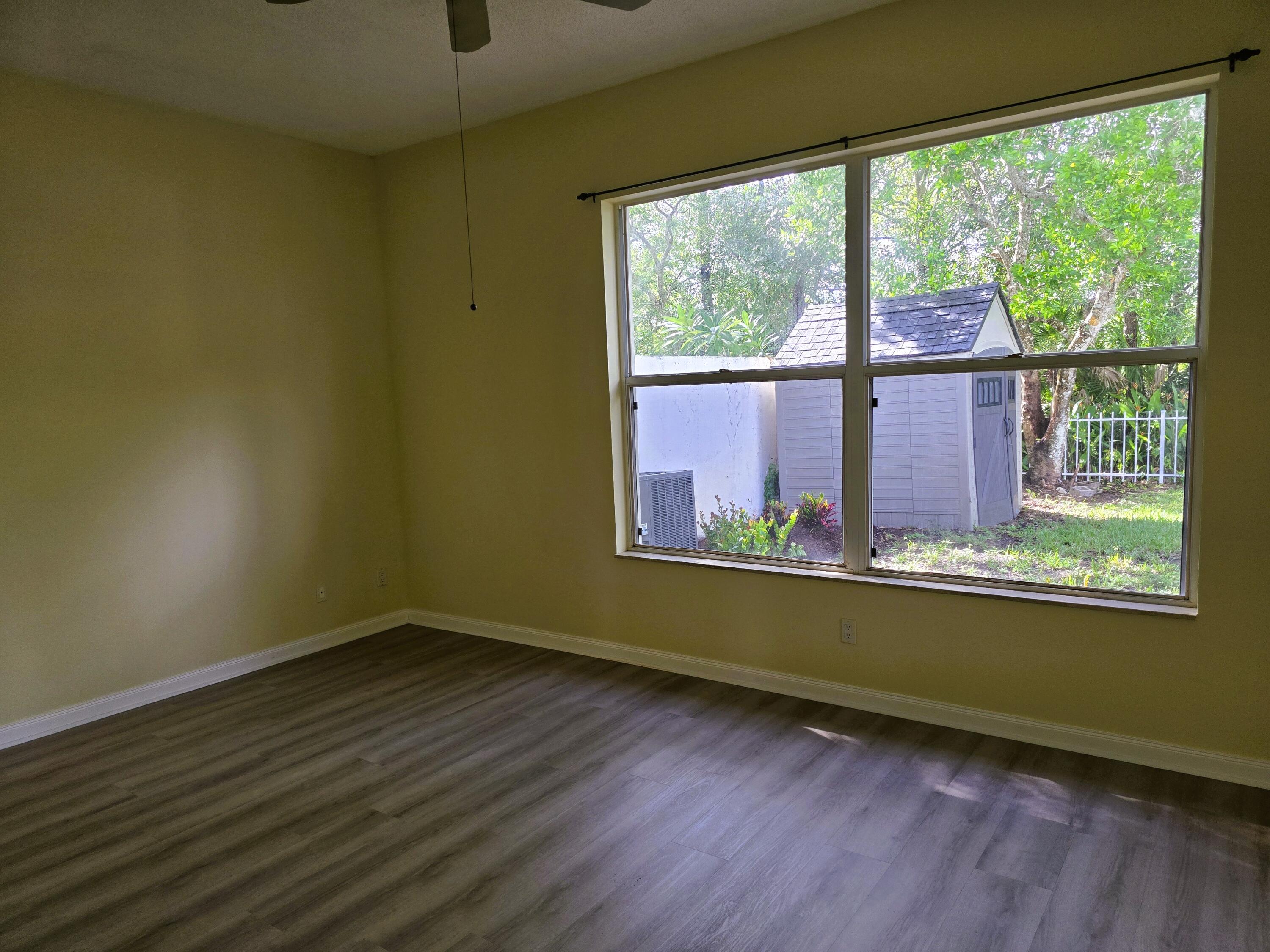 5131 Southeast Sweetbrier Terrace Hobe Sound, FL 33455 - Photo 6 of 18 an empty room with wooden floor and windows