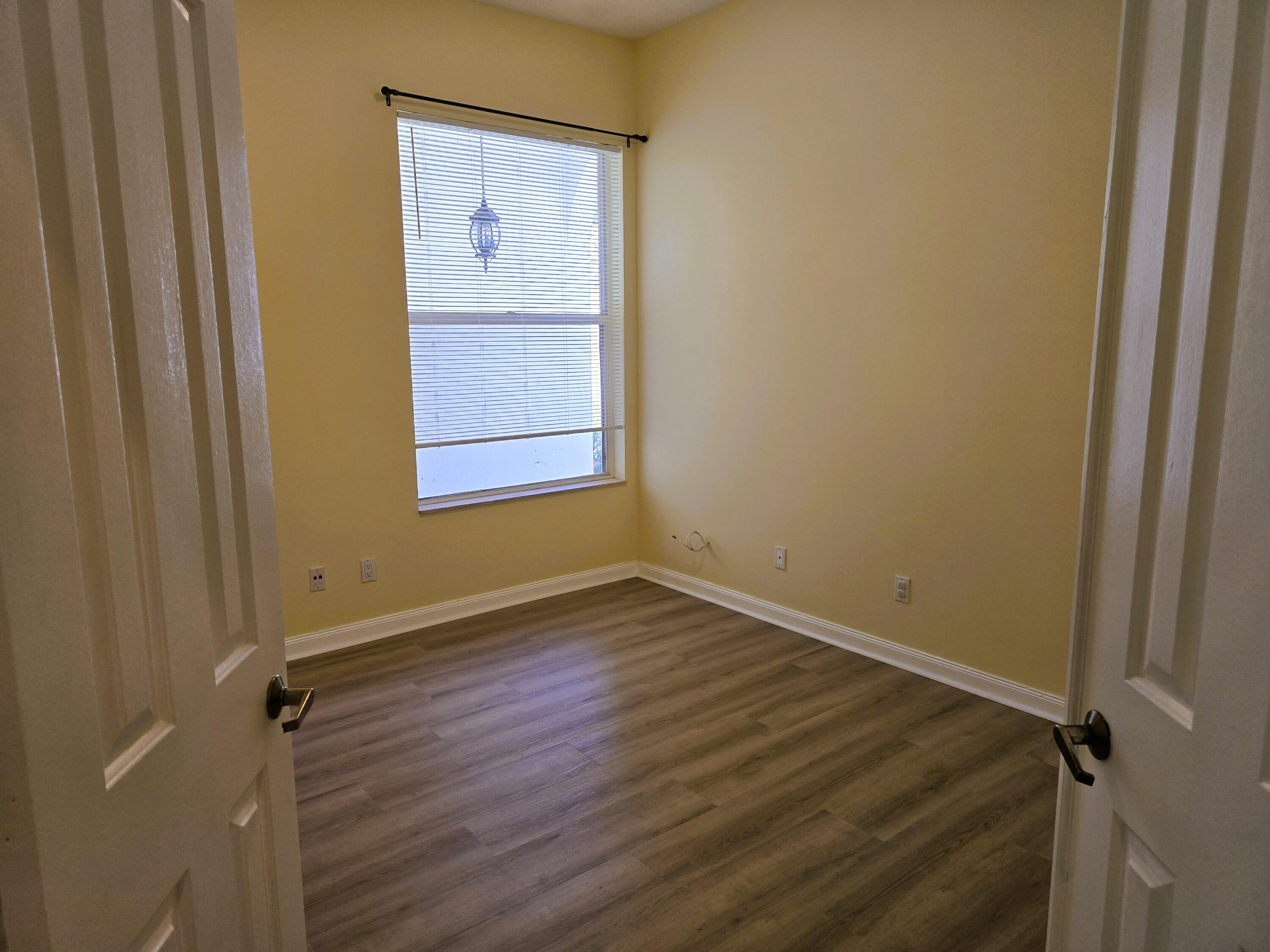 5131 Southeast Sweetbrier Terrace Hobe Sound, FL 33455 - Photo 8 of 18 a view of an empty room with wooden floor and a window