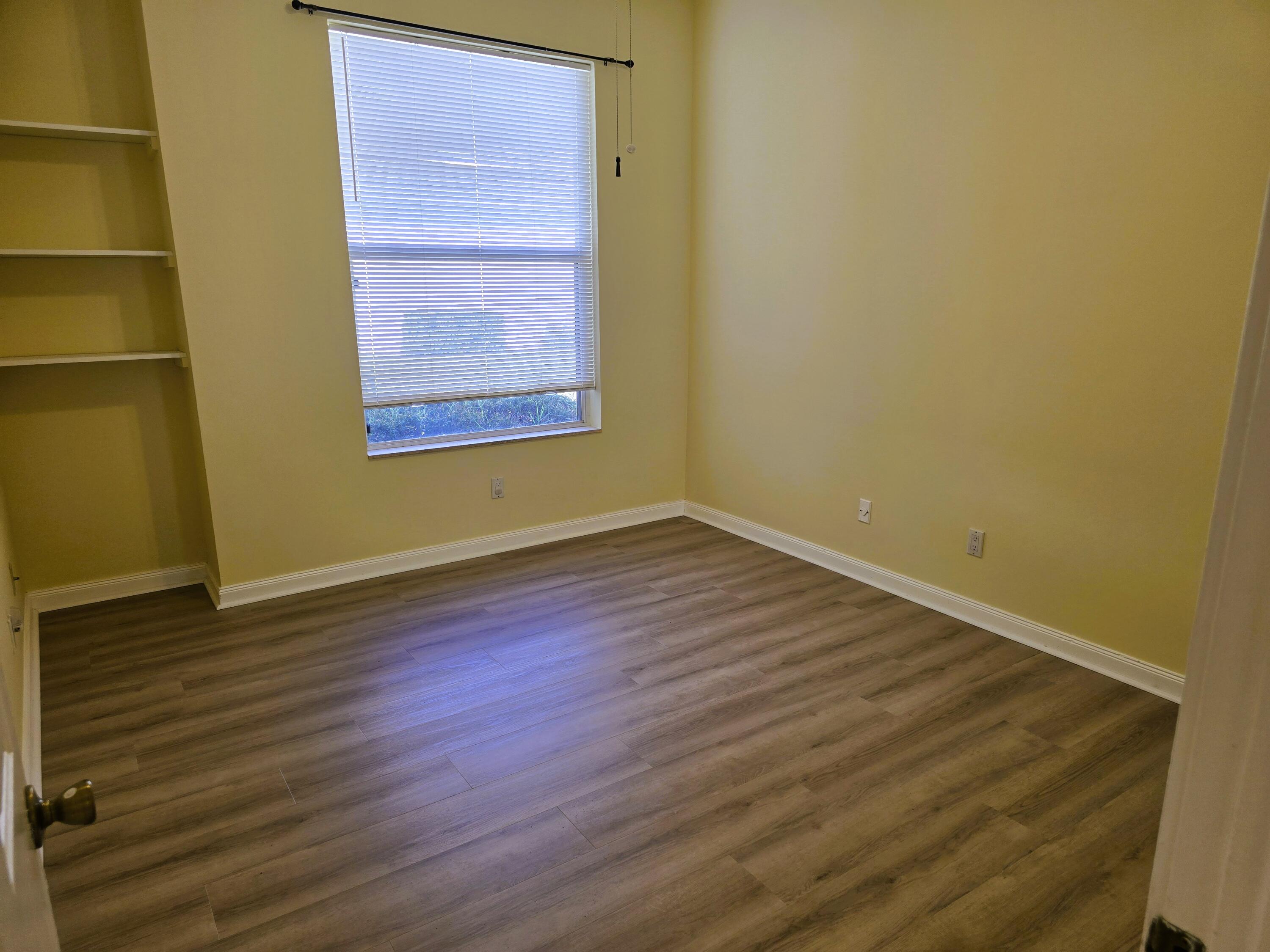 5131 Southeast Sweetbrier Terrace Hobe Sound, FL 33455 - Photo 10 of 18 a view of an empty room with wooden floor and a window