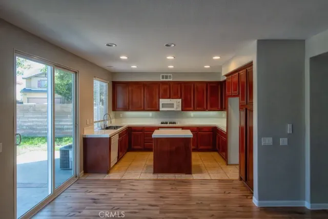 a kitchen with stainless steel appliances granite countertop a refrigerator a sink and a cabinets