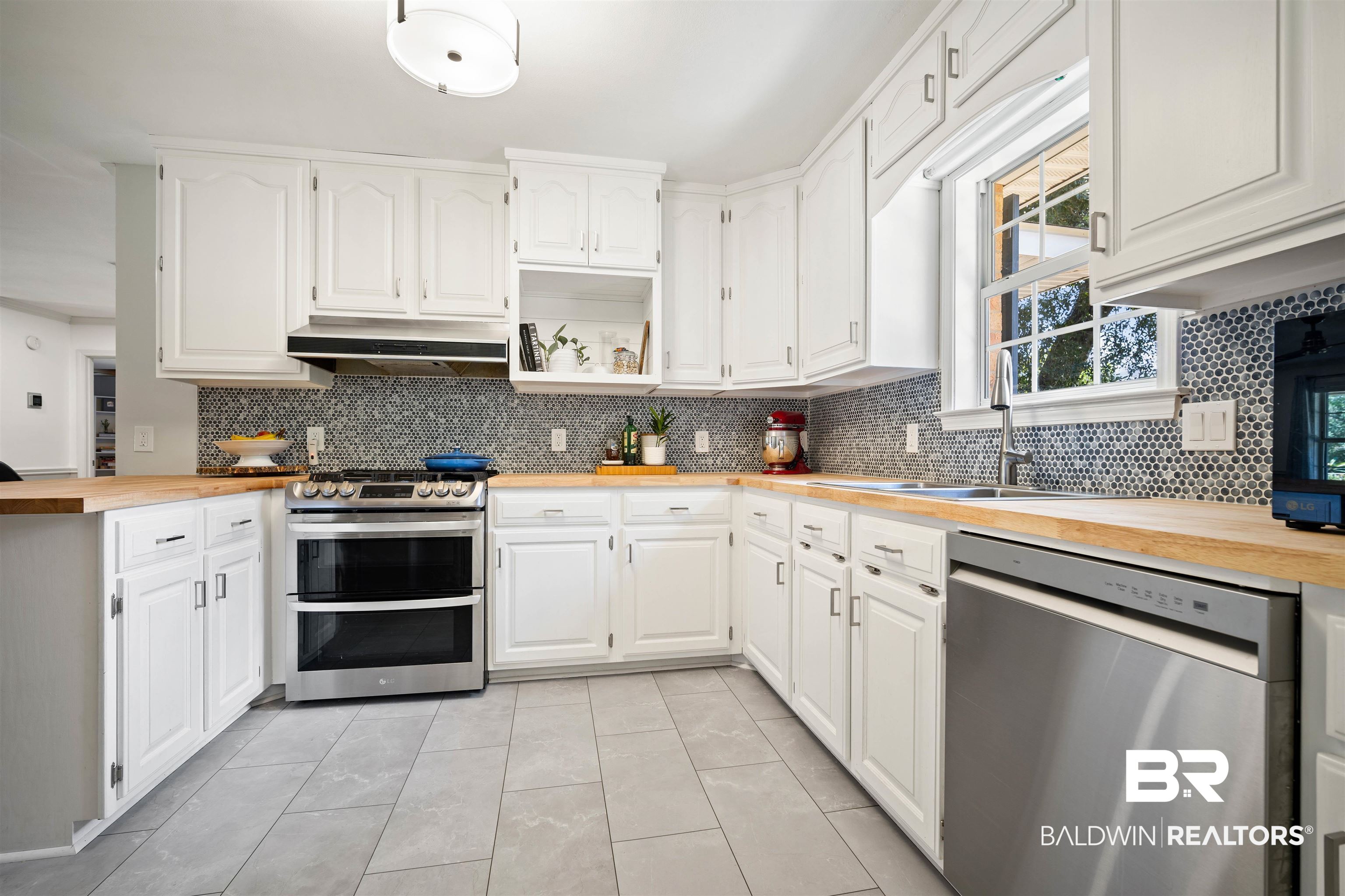 808 Michigan Avenue Fairhope, AL 36532 - Photo 12 of 33 Kitchen with white cabinetry, backsplash, stainless steel appliances, range hood, and wood counters