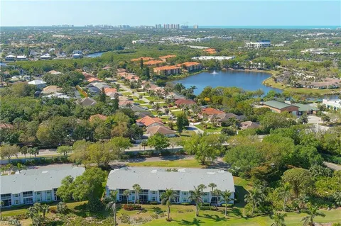 an aerial view of residential houses with outdoor space and lake view