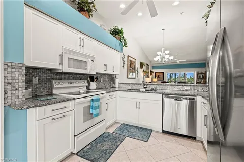 a kitchen with stainless steel appliances granite countertop a sink a stove a refrigerator and cabinets
