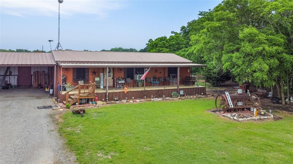 202 Darwin Road Whitewright, TX 75491 - Photo 1 of 1 View of front of property featuring driveway, metal roof, an attached carport, and a front yard