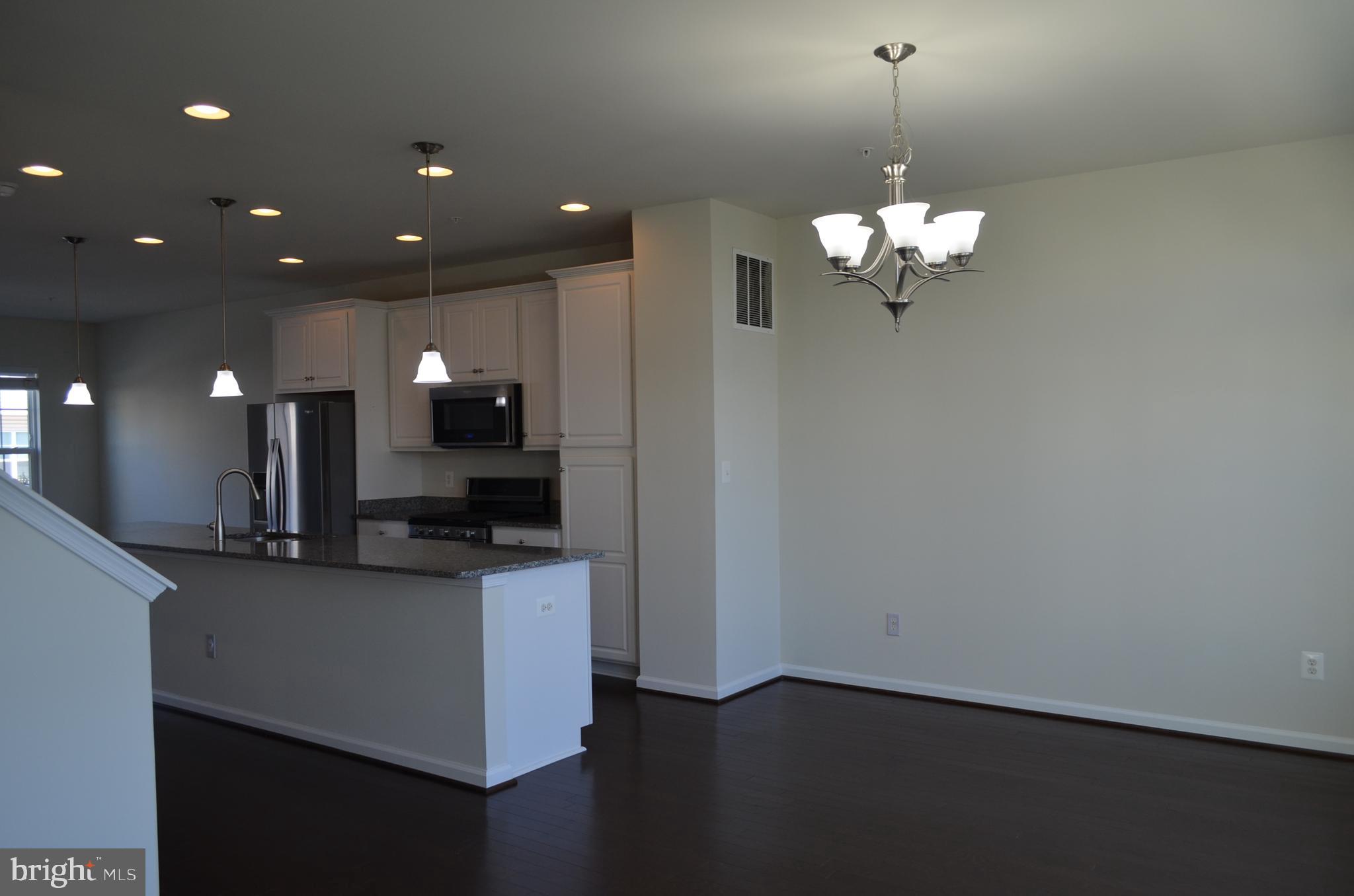 6004 Forum Frederick, MD 21703 - Photo 6 of 30 a view of a kitchen with a sink dishwasher a refrigerator and wooden floor