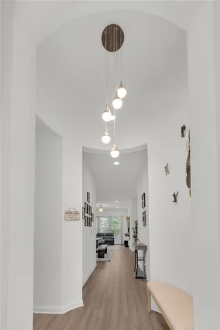a view of a hallway with wooden floor and chandelier