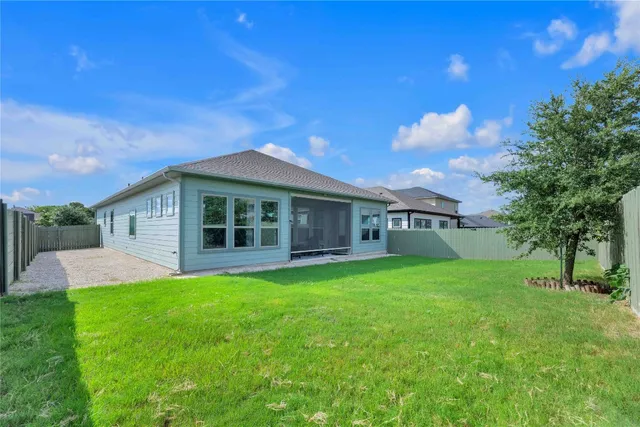 a view of a house with a big yard potted plants and large tree