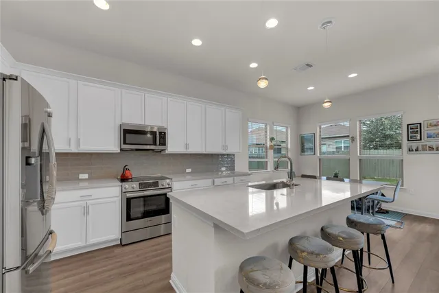 a kitchen with stainless steel appliances kitchen island granite countertop a sink and cabinets